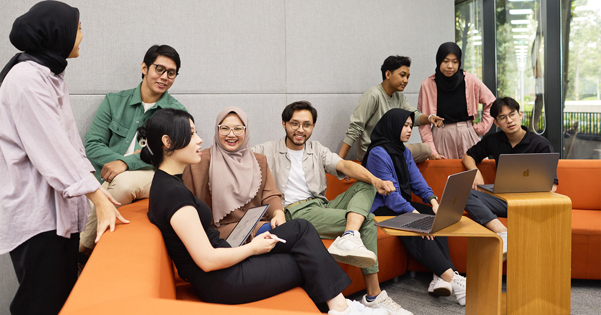 开发者们在设有橙色沙发的休息区进行协作